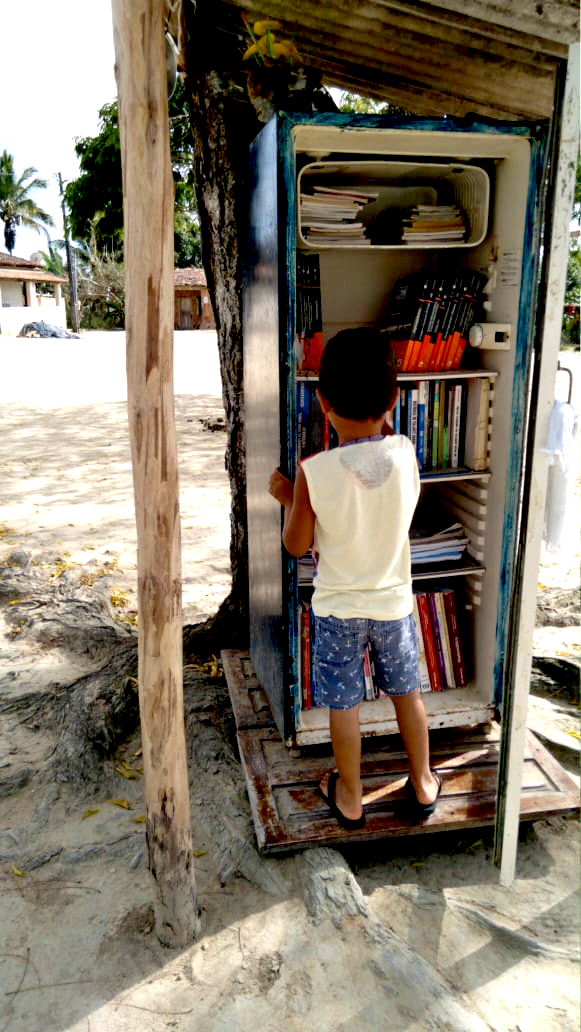 Criança com geladeira de livros
